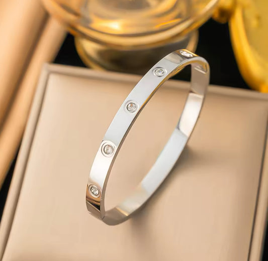 Close up view of elegant 18k Silver plated stainless steel, Cartier dupe, designer inspired, classic bangle bracelet with a smooth, polished finish and crystal inlay, designed with a lightweight and tarnish resistant material for timeless sophistication.